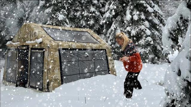 Cozy tent camp with stove in heavy snowfall Cozy tent camp with stove in heavy snowfall