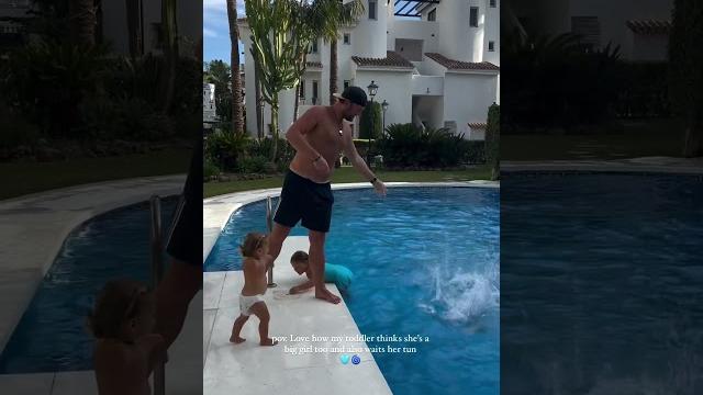 This toddler patiently waits for her turn to jump into the pool This toddler patiently waits for her turn to jump into the pool