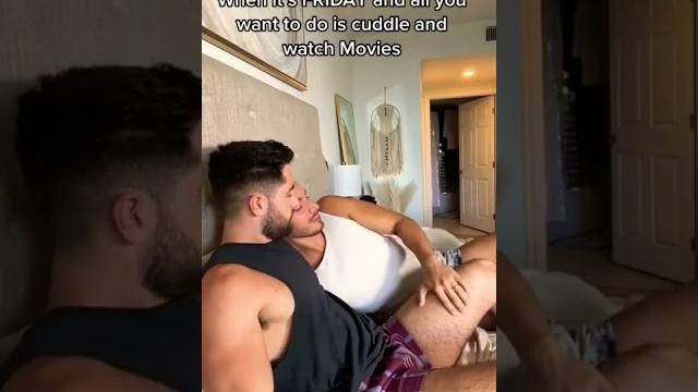 Gay couple on bed cuddling , hugging , kissing , loving , romance , watching movies Gay couple on bed cuddling , hugging , kissing , loving , romance , watching movies