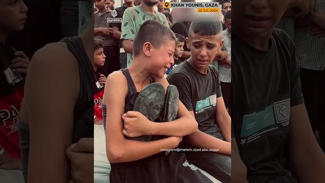 Palestinian boy holds shoes of killed father | #ajshorts Palestinian boy holds shoes of killed father | #ajshorts