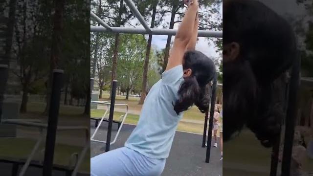 Cute girl doing monkey bars Cute girl doing monkey bars