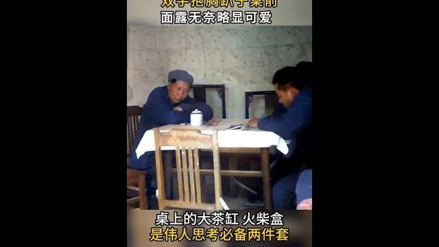 The image of chairman mao listening to the radio was exposed. he sat on the desk with his hands hol The image of chairman mao listening to the radio was exposed. he sat on the desk with his hands hol