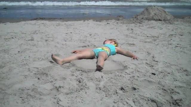 Grace making sand angels..... Grace making sand angels.....