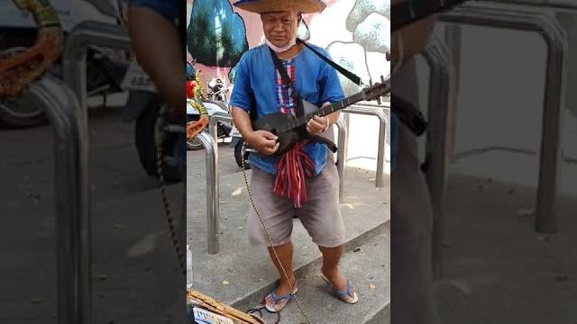 Traditional pin or phin guitar played by cute thai girl in bangkok thailand with her father Traditional pin or phin guitar played by cute thai girl in bangkok thailand with her father