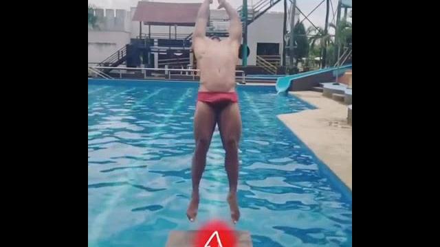 Garoto sarado pulando na piscina Garoto sarado pulando na piscina