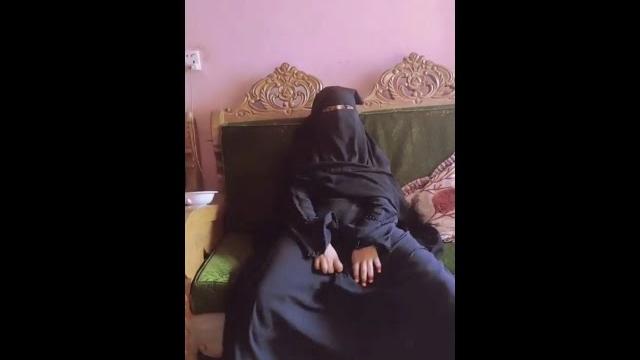 What is the girl wearing hijab doing? What is the girl wearing hijab doing?